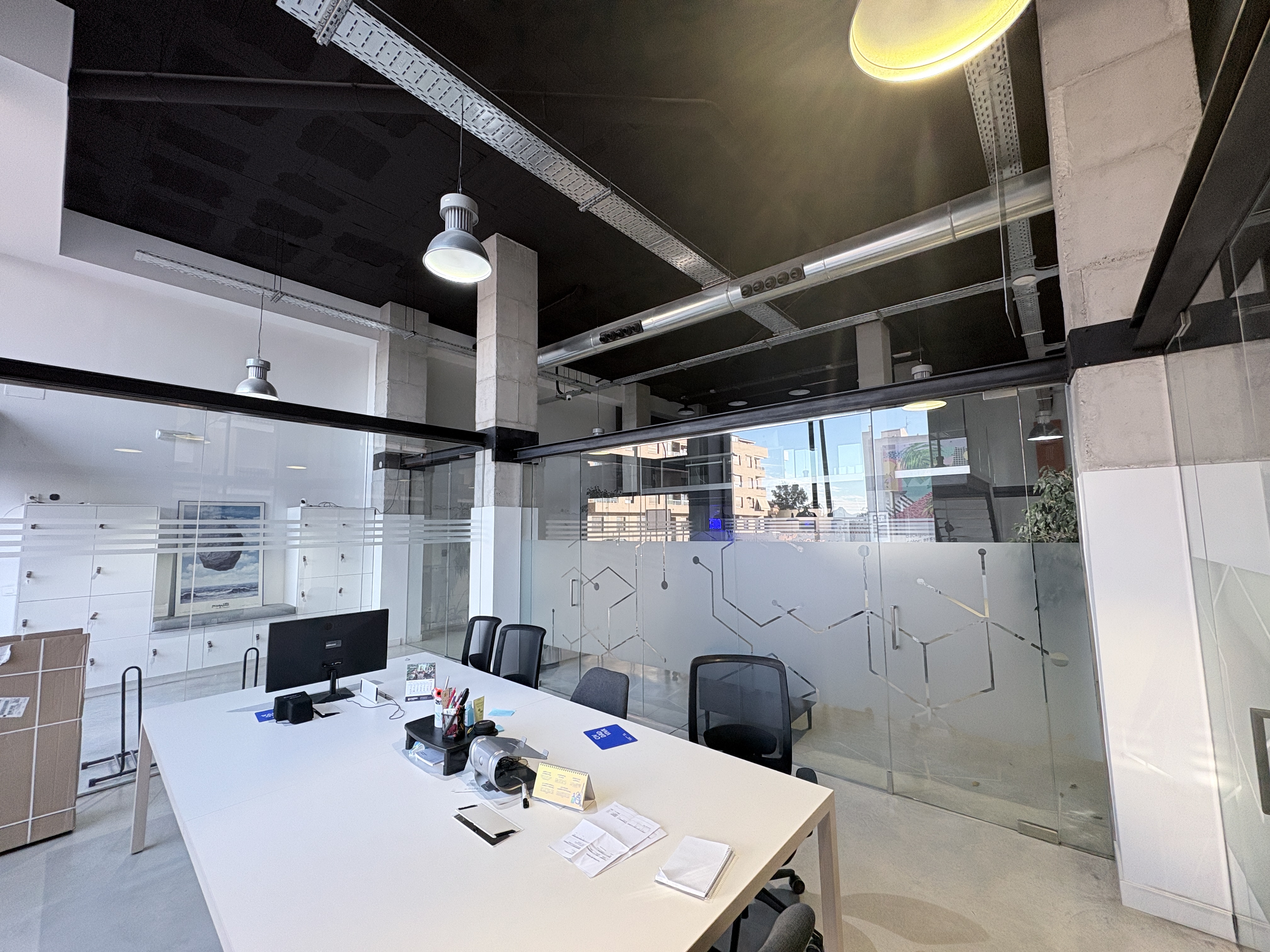 Mesa de trabajo junto a sala acristalada